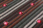 Vier leuchtende Rotlicht-LEDs zwischen den Mineralperlen-Streifen der Matte